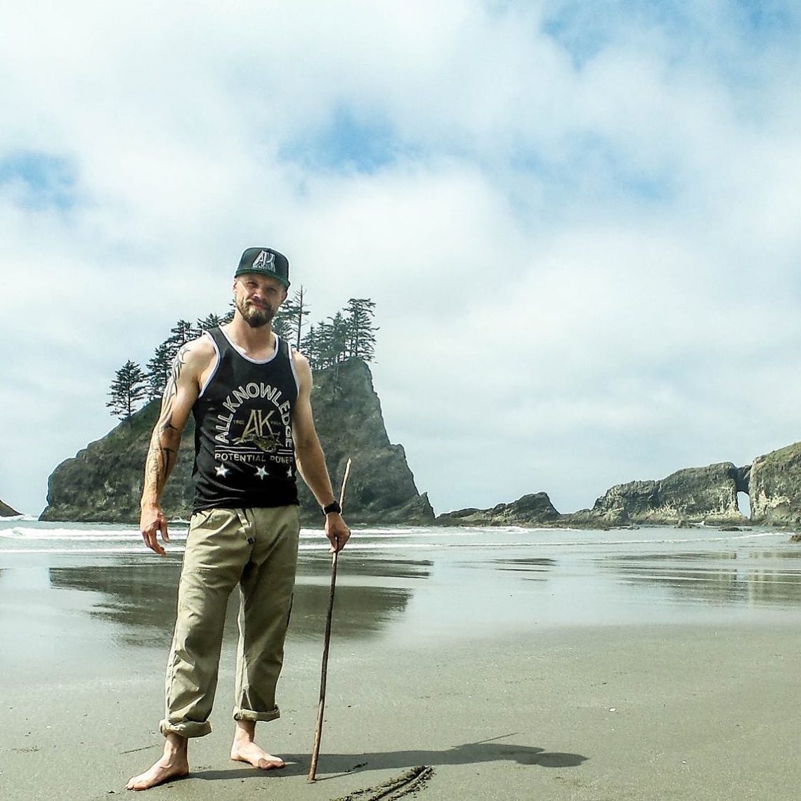 Men in a beach in Oregon with all knowledge potential power t-shirt