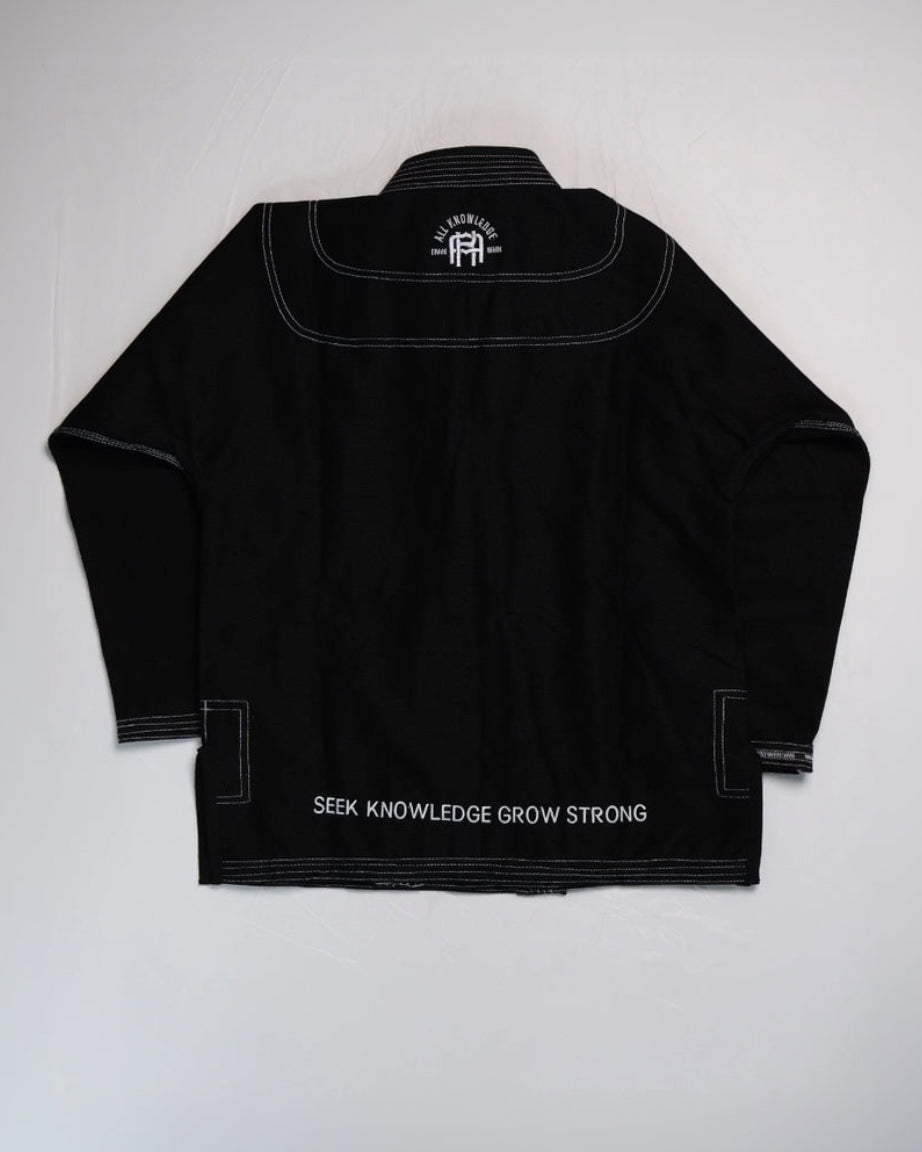 Black Stoic jiu-jitsu gi with 'Seek Knowledge Grow Strong' text on a white background